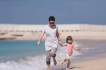 Image showing mother and daughter running on the beach