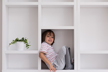 Image showing young boy posing on a shelf