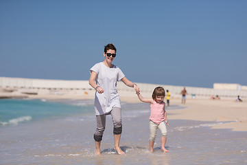 Image showing mother and daughter running on the beach