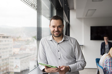 Image showing Businessman Using Tablet In Office Building by window