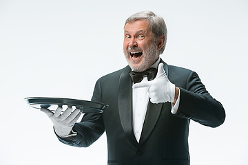 Image showing Senior waiter holding tray