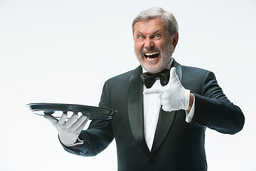 Image showing Senior waiter holding tray