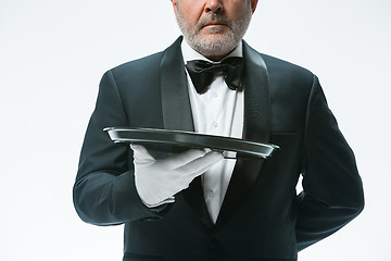 Image showing Senior waiter holding tray