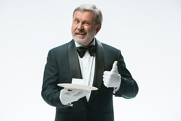 Image showing Senior waiter holding tray