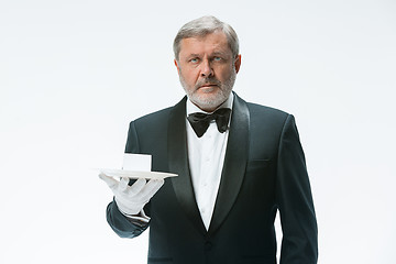 Image showing Senior waiter holding tray