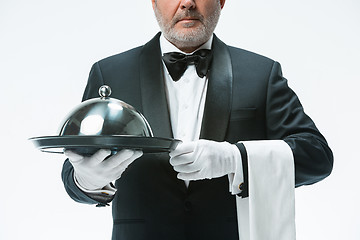 Image showing Senior waiter holding tray