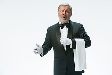 Image showing Senior waiter holding white towel