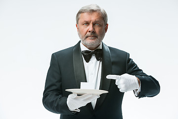 Image showing Senior waiter holding tray