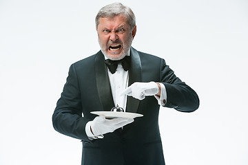 Image showing Senior waiter holding bell