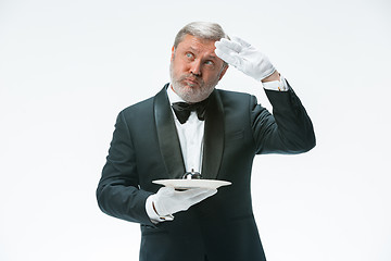 Image showing Senior waiter holding bell