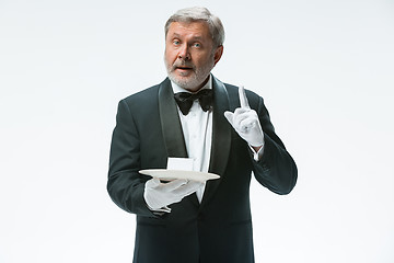 Image showing Senior waiter holding tray