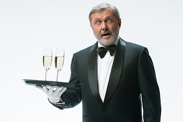 Image showing professional waiter in uniform is serving wine