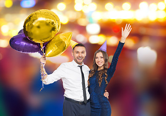 Image showing happy couple with party caps and balloons