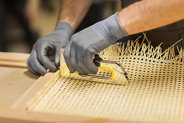 Image showing assembler with staple gun making furniture