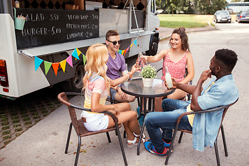 Image showing friends clinking bottles with drinks at food truck