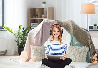 Image showing girl with headphones and tablet pc at home