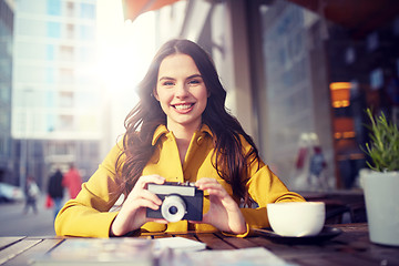 Image showing happy tourist woman with camera at city cafe