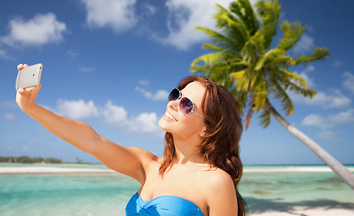 Image showing woman taking selfie by smartphone on beach