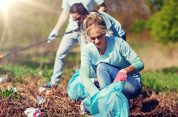 Image showing volunteers with garbage bags cleaning park area