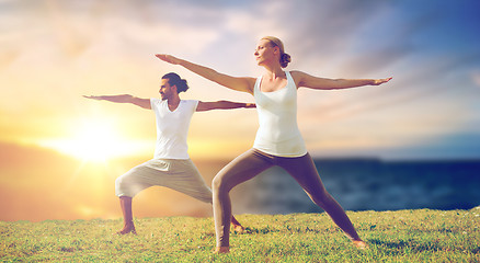 Image showing couple making yoga warrior pose outdoors