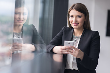 Image showing Business Girl Standing In A Modern Building Near The Window With