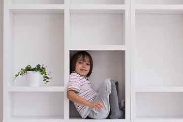 Image showing young boy posing on a shelf