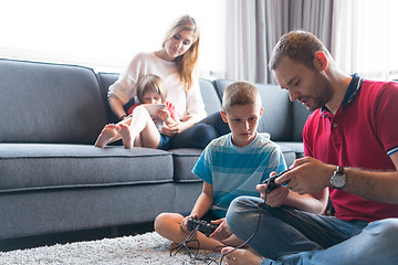 Image showing Happy family playing a video game