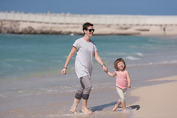 Image showing mother and daughter running on the beach