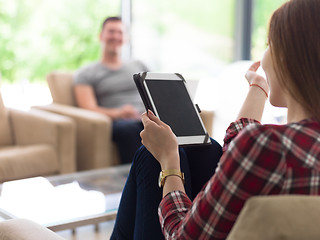 Image showing couple relaxing at  home with tablet and laptop computers