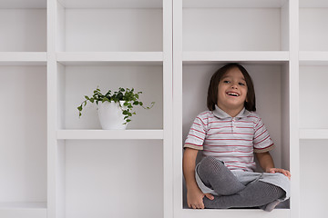 Image showing young boy posing on a shelf