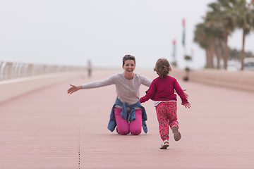 Image showing mother and cute little girl on the promenade by the sea