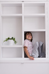 Image showing young boy posing on a shelf