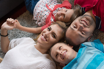 Image showing happy family lying on the floor