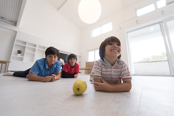 Image showing boys having fun with an apple on the floor