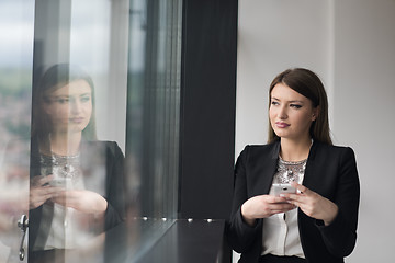 Image showing Business Girl Standing In A Modern Building Near The Window With