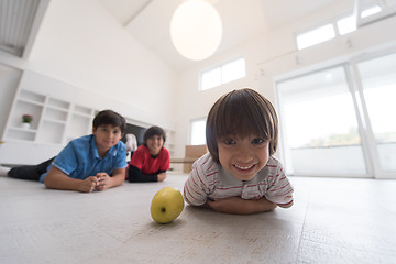 Image showing boys having fun with an apple on the floor