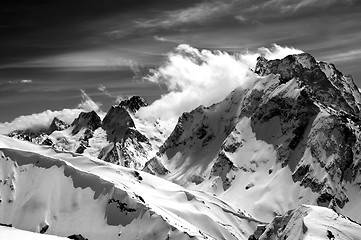 Image showing Black and white winter mountains with snow cornice and cloudy sk