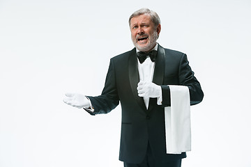 Image showing Senior waiter holding white towel