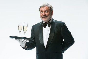 Image showing professional waiter in uniform is serving wine