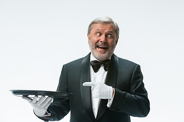 Image showing Senior waiter holding tray