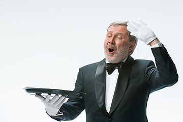 Image showing Senior waiter holding tray