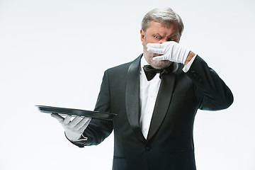 Image showing Senior waiter holding tray