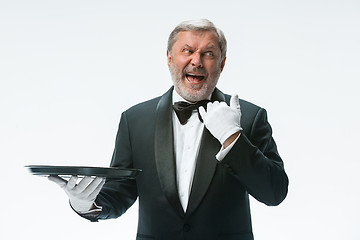 Image showing Senior waiter holding tray