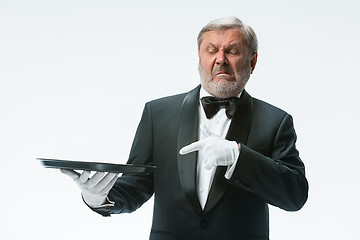 Image showing Senior waiter holding tray