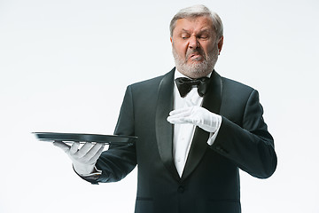 Image showing Senior waiter holding tray