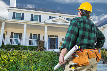 Image showing Male Contractor with Hard Hat and Tool Belt Looking At Custom Ho