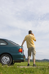 Image showing Man talking on cell phone beside his car