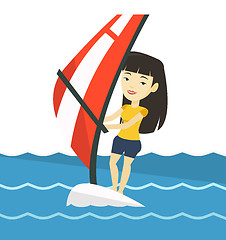 Image showing Young woman windsurfing in the sea.