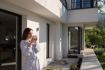 Image showing woman in a bathrobe enjoying morning coffee