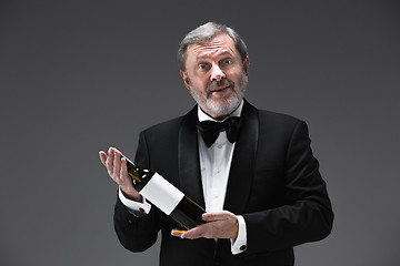 Image showing professional waiter in uniform is serving wine